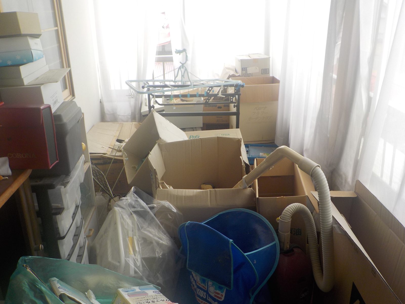 段ボールや生活用品が残された作業前の部屋