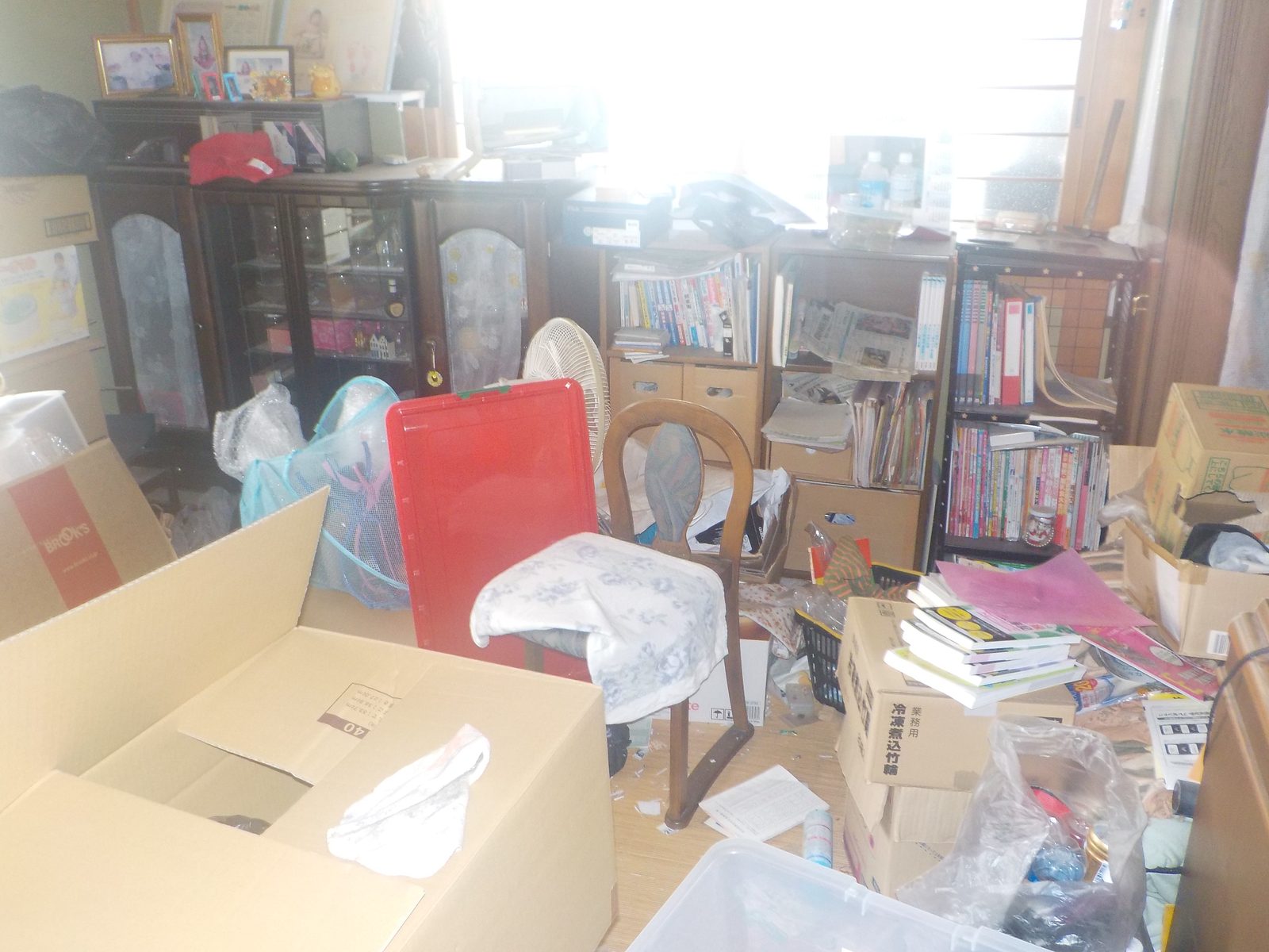 本や家具などが残された作業前の部屋